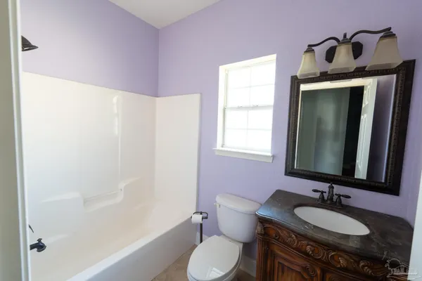 a bathroom with a granite countertop sink toilet and mirror