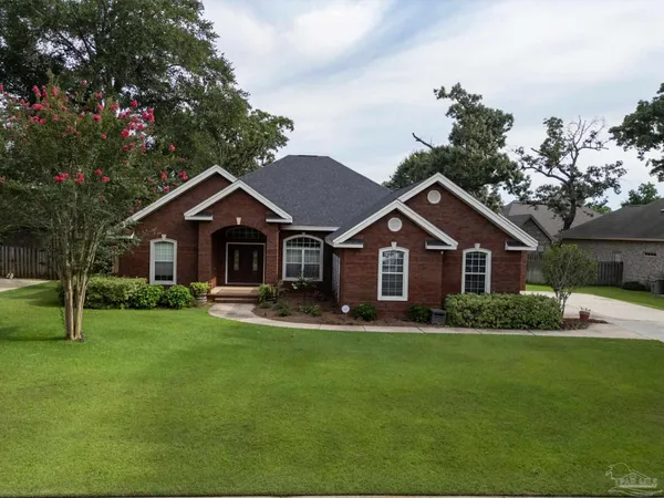 a front view of a house with a yard and trees