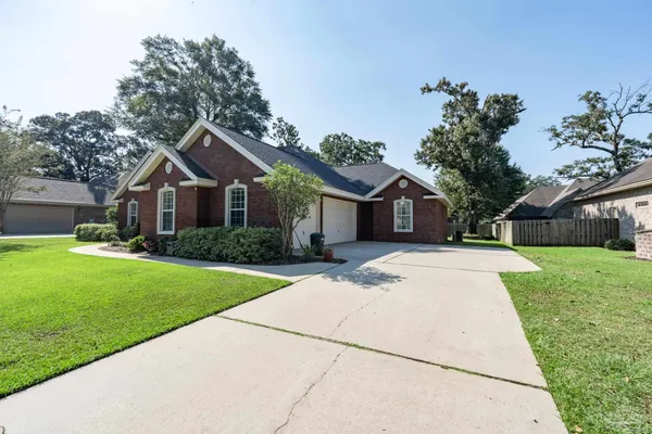 a front view of a house with a yard and trees