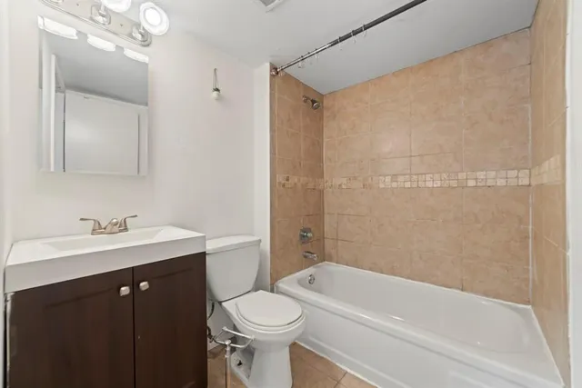 a bathroom with a bathtub shower sink vanity and toilet