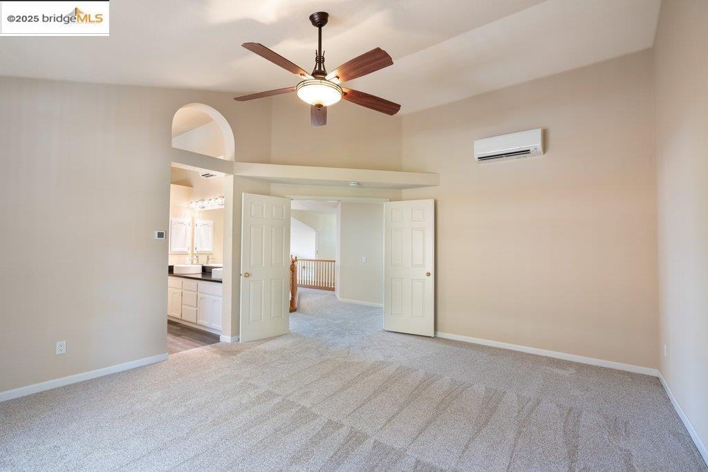1003 Linda Vista Way Rio Vista, CA 94571 - Photo 26 of 60 Unfurnished bedroom with light colored carpet, an AC wall unit, ensuite bathroom, a high ceiling, and ceiling fan