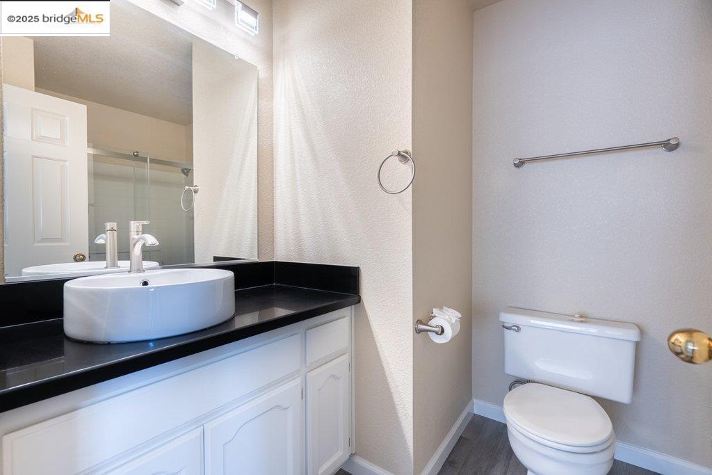 1003 Linda Vista Way Rio Vista, CA 94571 - Photo 40 of 60 Full bathroom featuring vanity, a shower with door, wood finished floors, and a textured wall