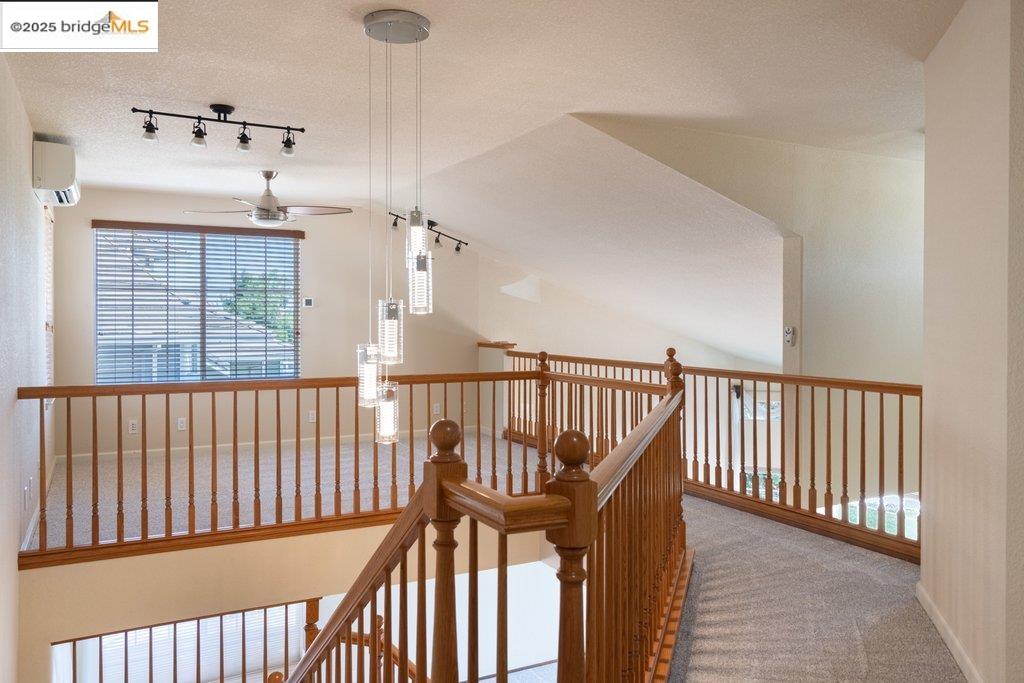 1003 Linda Vista Way Rio Vista, CA 94571 - Photo 47 of 60 Hallway with carpet flooring, track lighting, a textured ceiling, vaulted ceiling, and an AC wall unit