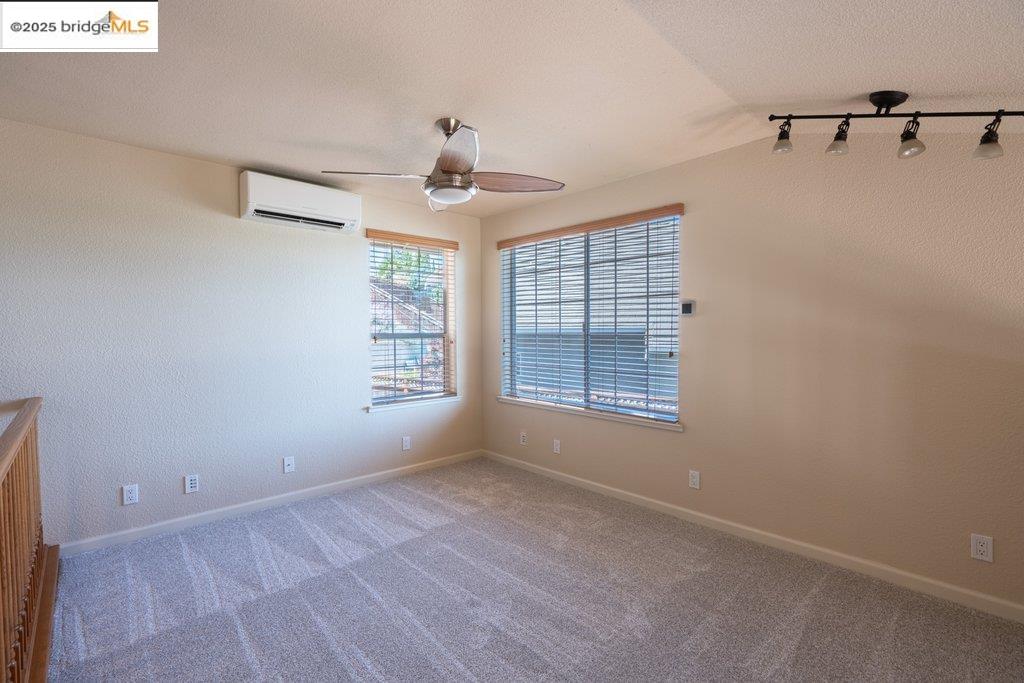 1003 Linda Vista Way Rio Vista, CA 94571 - Photo 48 of 60 Spare room featuring carpet, track lighting, a textured wall, a textured ceiling, and an AC wall unit