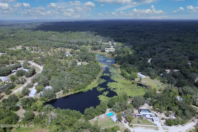 a living room with stainless steel appliances granite countertop furniture wooden floor and a view of kitchen