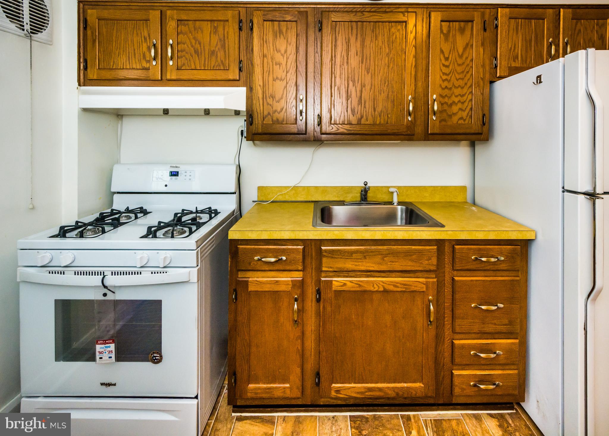 3829 Monterey Road Baltimore, MD 21218 - Photo 10 of 25 a kitchen with granite countertop cabinets and refrigerator stove
