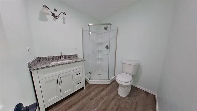 a bathroom with a granite countertop toilet a sink and a shower