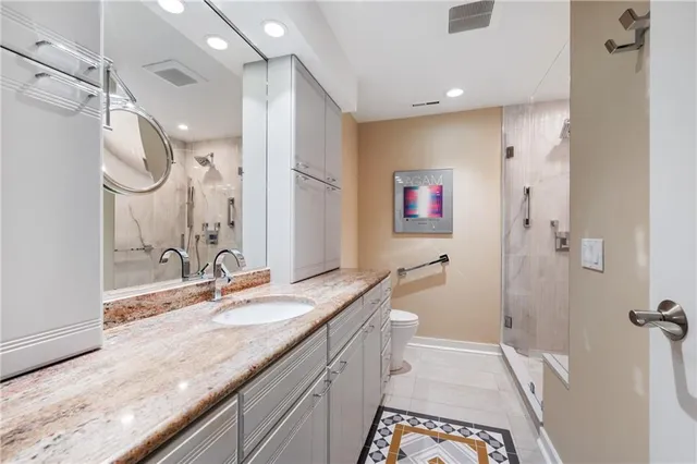 a spacious bathroom with a granite countertop sink mirror and a shower