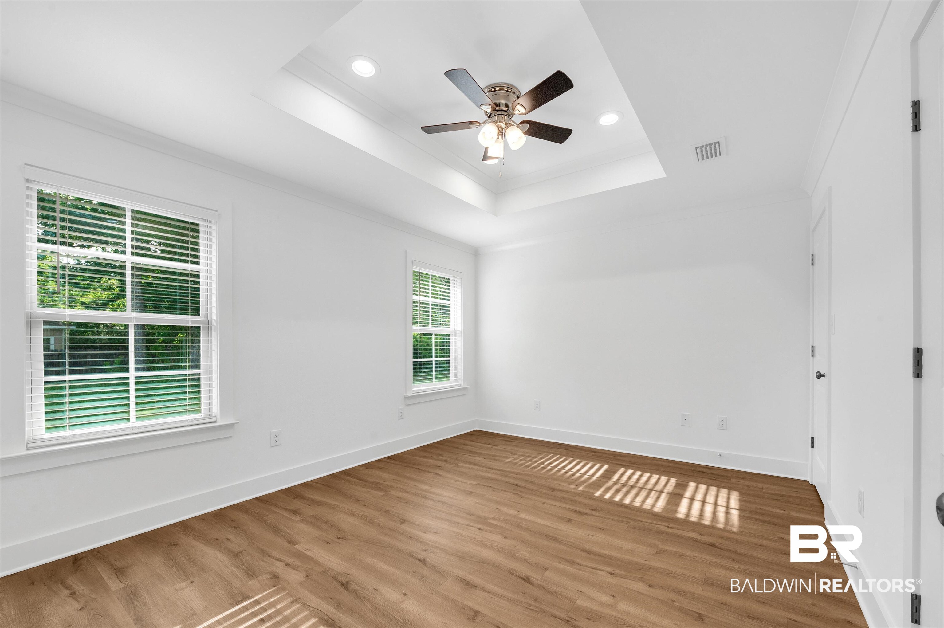 22045 8th Street Silverhill, AL 36576 - Photo 22 of 39 Primary bedroom featuring ornamental molding, ceiling fan, a raised ceiling, wood finished floors, and recessed lighting