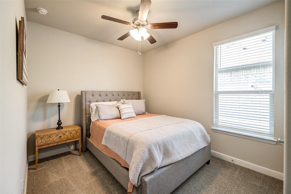 145 Hawksbill Lane Rhome, TX 76078 - Photo 14 of 23 a bedroom with a bed and a chandelier