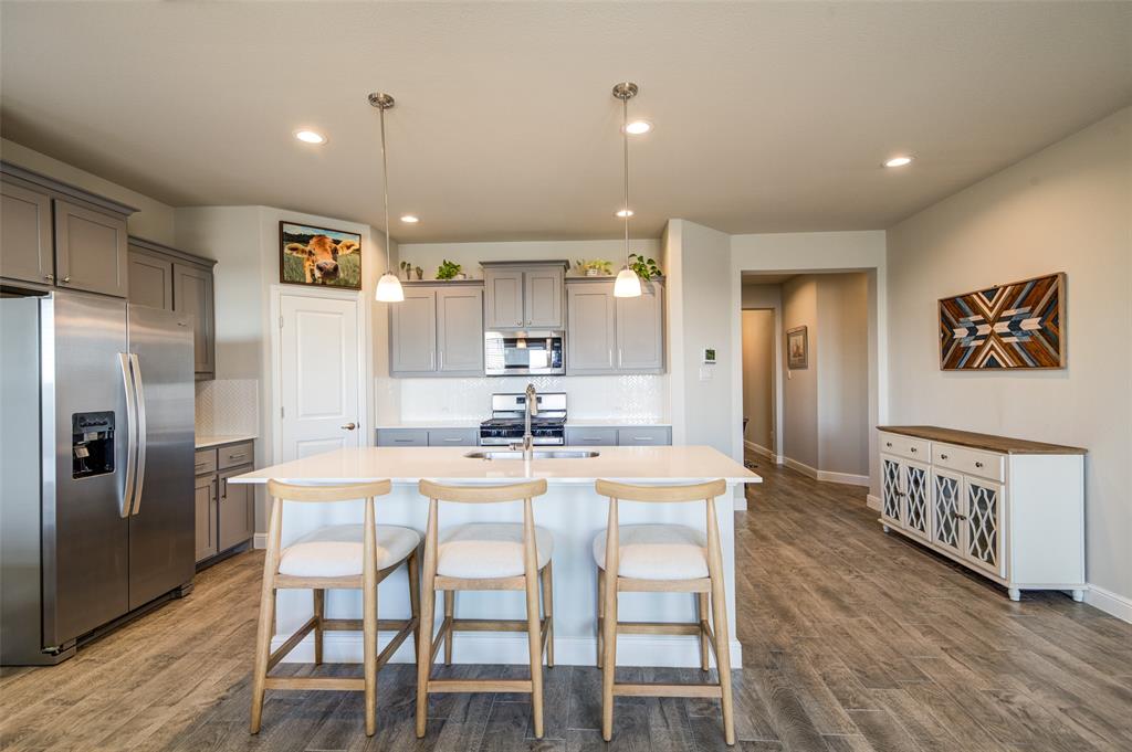 145 Hawksbill Lane Rhome, TX 76078 - Photo 7 of 23 a kitchen with stainless steel appliances kitchen island granite countertop a dining table chairs and refrigerator
