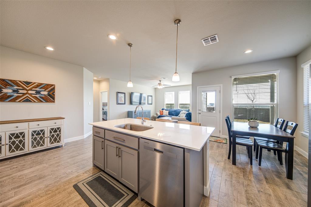 145 Hawksbill Lane Rhome, TX 76078 - Photo 8 of 23 a open kitchen with stainless steel appliances granite countertop a sink a stove and a wooden floors