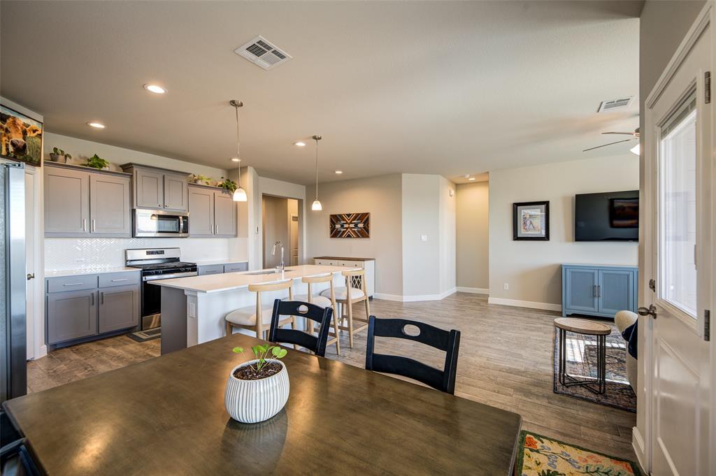 145 Hawksbill Lane Rhome, TX 76078 - Photo 9 of 23 a kitchen with a table chairs microwave and cabinets