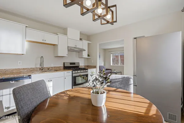 a kitchen with stainless steel appliances granite countertop a stove and white cabinets