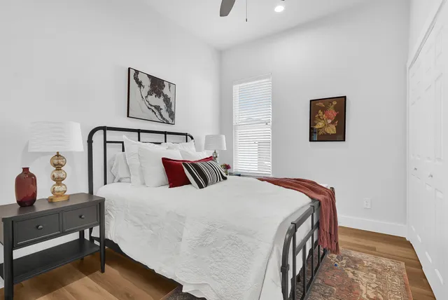 a bedroom with a bed and painting on the wall