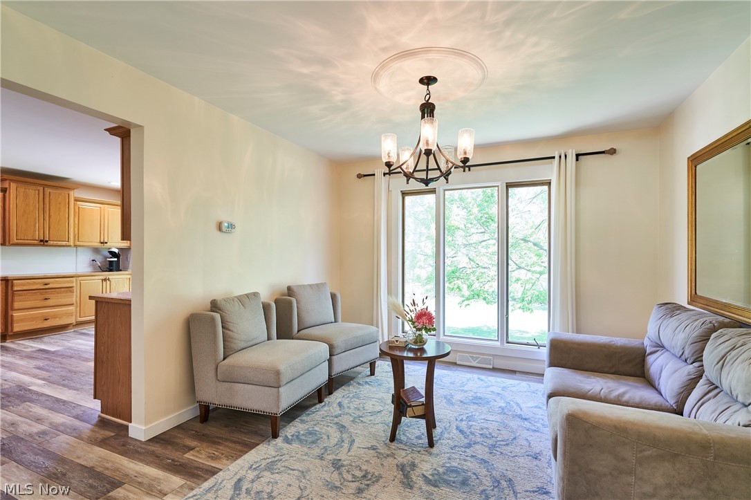 1535 Belle Meade Drive Akron, OH 44321 - Photo 5 of 33 The formal dining room is currently being used as a sitting room with floor-to-ceiling window offering wonderful views of the backyard. The room features newer LVT flooring, paint, and a chandelier.