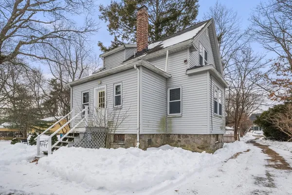 a view of a house with a yard covered in snow