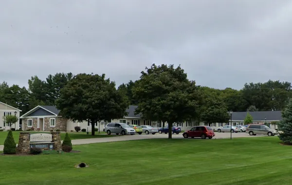 a group of cars parked in front of house with yard
