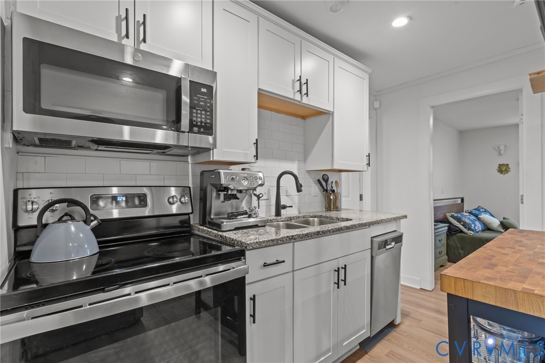 8874 Strath Road Henrico, VA 23231 - Photo 14 of 40 a kitchen with a stove and a microwave