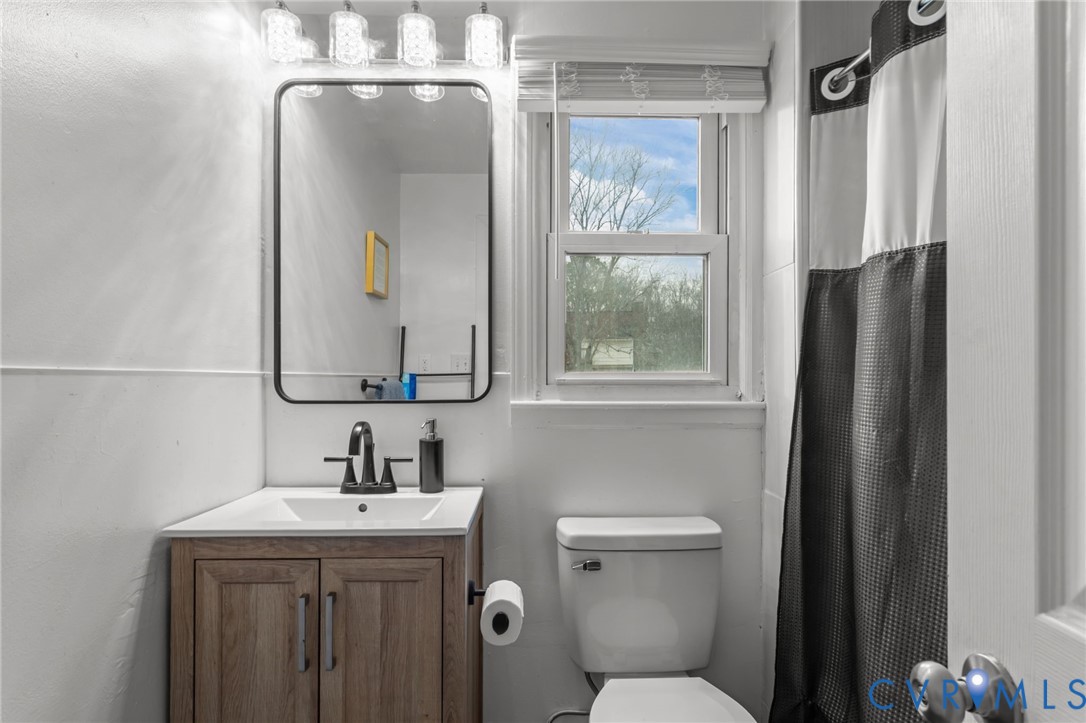 8874 Strath Road Henrico, VA 23231 - Photo 15 of 40 a bathroom with a toilet a sink a vanity and mirror