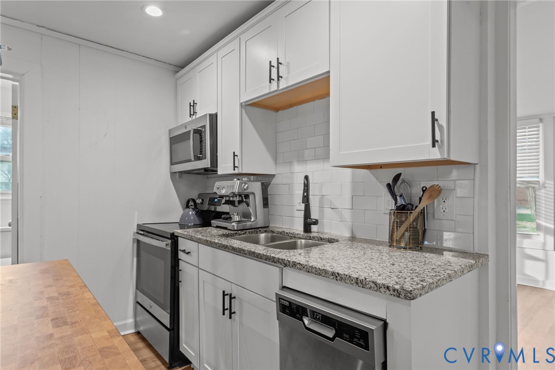 8874 Strath Road Henrico, VA 23231 - Photo 18 of 40 a kitchen with stainless steel appliances granite countertop a sink stove and cabinets