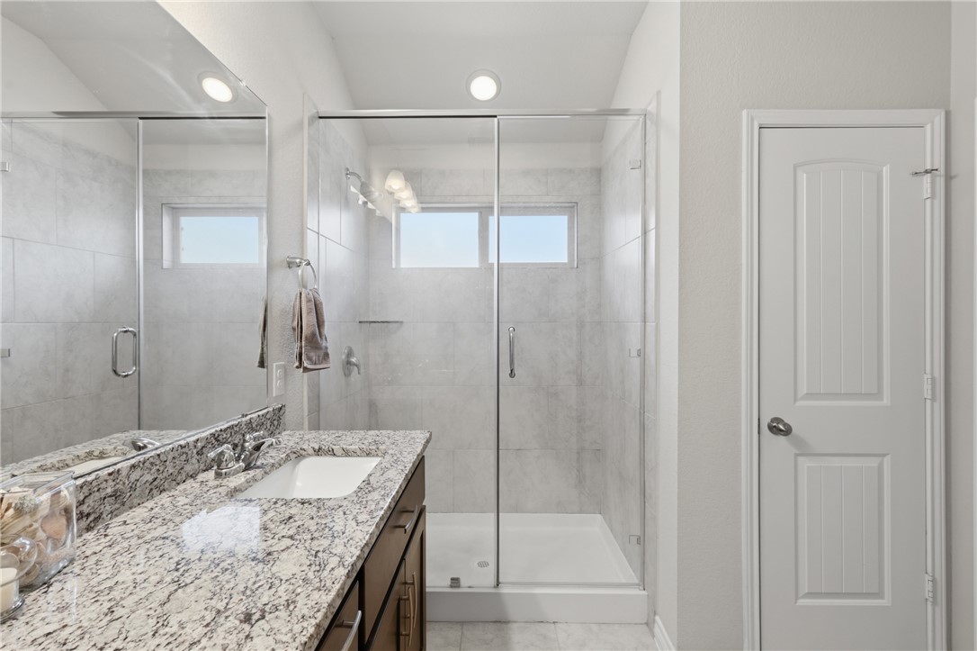 1943 Thorndyke Lane Bryan, TX 77807 - Photo 22 of 28 Granite countertops and a large walk in shower with natural light spilling in. Walk in closet not pictured!