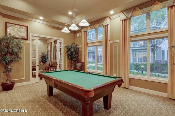 a room with pool table and windows