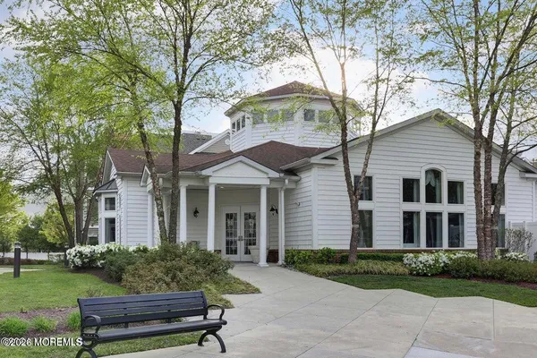 a brick house with a yard plants and large trees