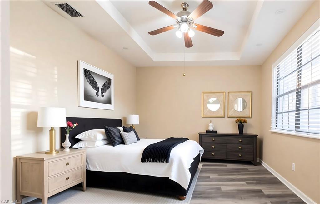 14751 Pinnacle Place, Unit 343 Naples, FL 34119 - Photo 17 of 24 Bedroom featuring wood finished floors, a raised ceiling, and a ceiling fan