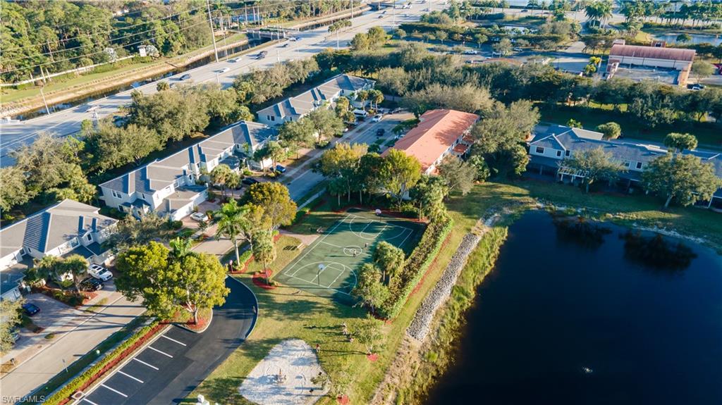 14751 Pinnacle Place, Unit 343 Naples, FL 34119 - Photo 21 of 24 Aerial view of property and surrounding area featuring a nearby body of water and nearby suburban area