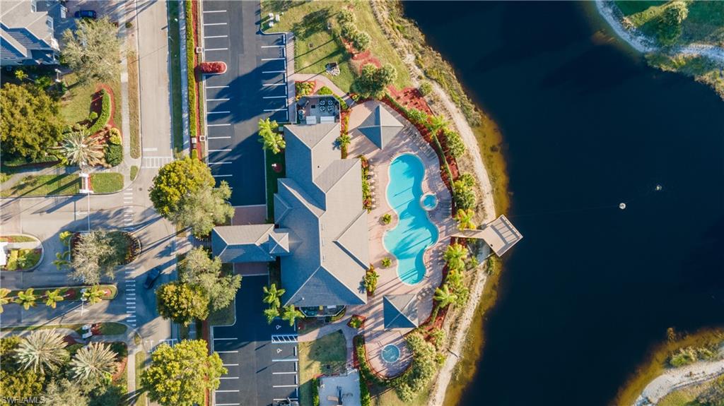 14751 Pinnacle Place, Unit 343 Naples, FL 34119 - Photo 24 of 24 Drone / aerial view of a pool area and a large body of water