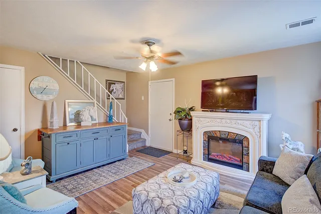 a living room with furniture a flat screen tv and a fireplace