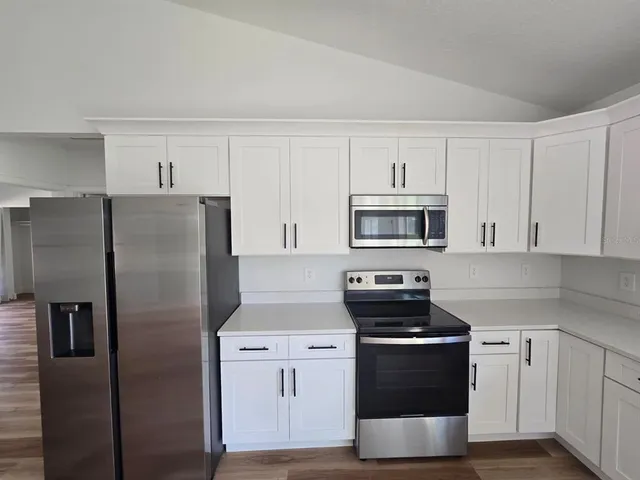 a kitchen with stainless steel appliances a refrigerator stove and microwave