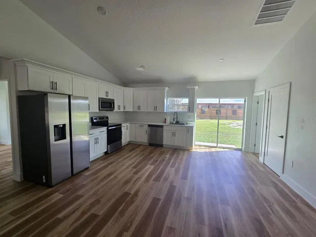 a kitchen with stainless steel appliances wooden floors and wooden cabinets