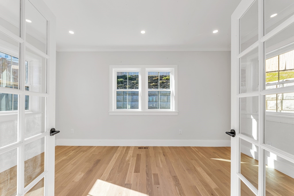 415 Poplar Street Boston, MA 02131 - Photo 12 of 31 a view of an empty room with wooden floor and a window