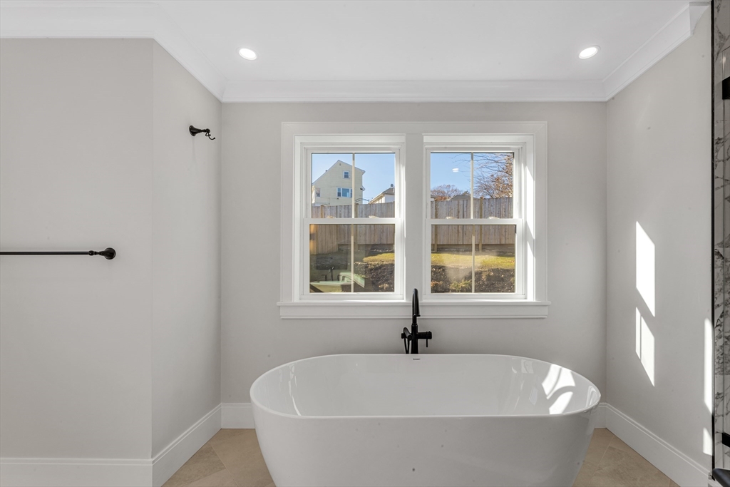415 Poplar Street Boston, MA 02131 - Photo 19 of 31 a white bath tub sitting in a bathroom next to a window