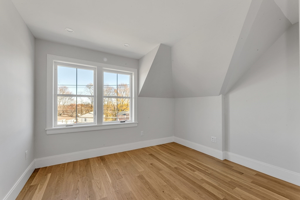 415 Poplar Street Boston, MA 02131 - Photo 21 of 31 an empty room with wooden floor and windows