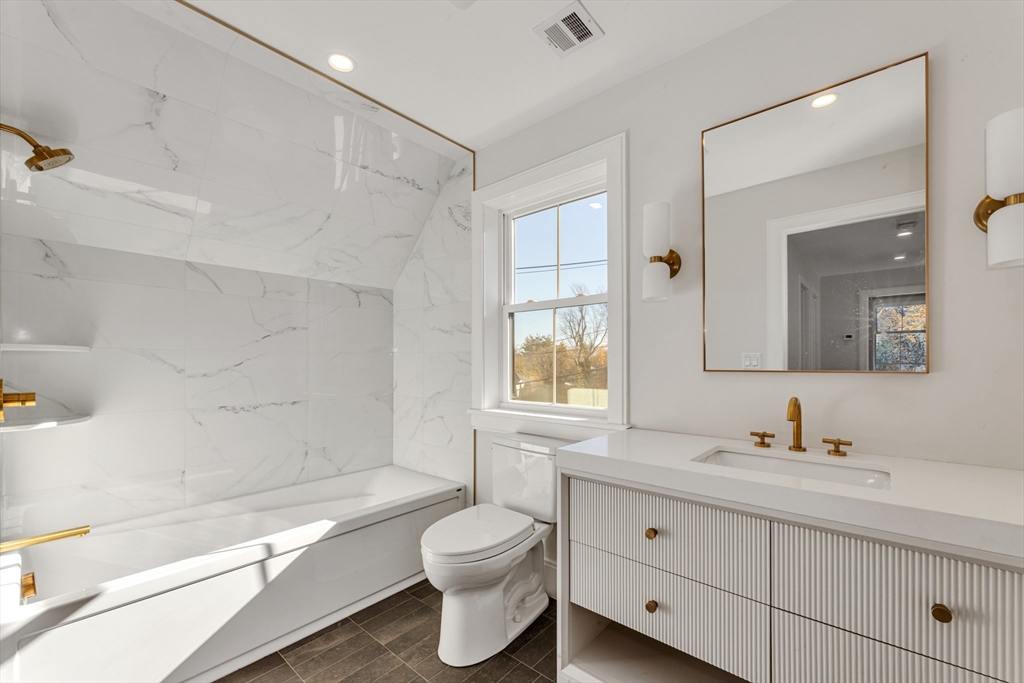 415 Poplar Street Boston, MA 02131 - Photo 22 of 31 a bathroom with a granite countertop toilet a sink and a bathtub