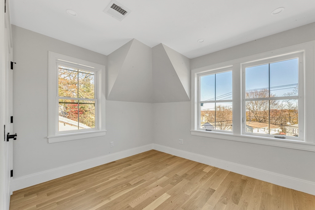 415 Poplar Street Boston, MA 02131 - Photo 23 of 31 a view of an empty room with wooden floor and a window