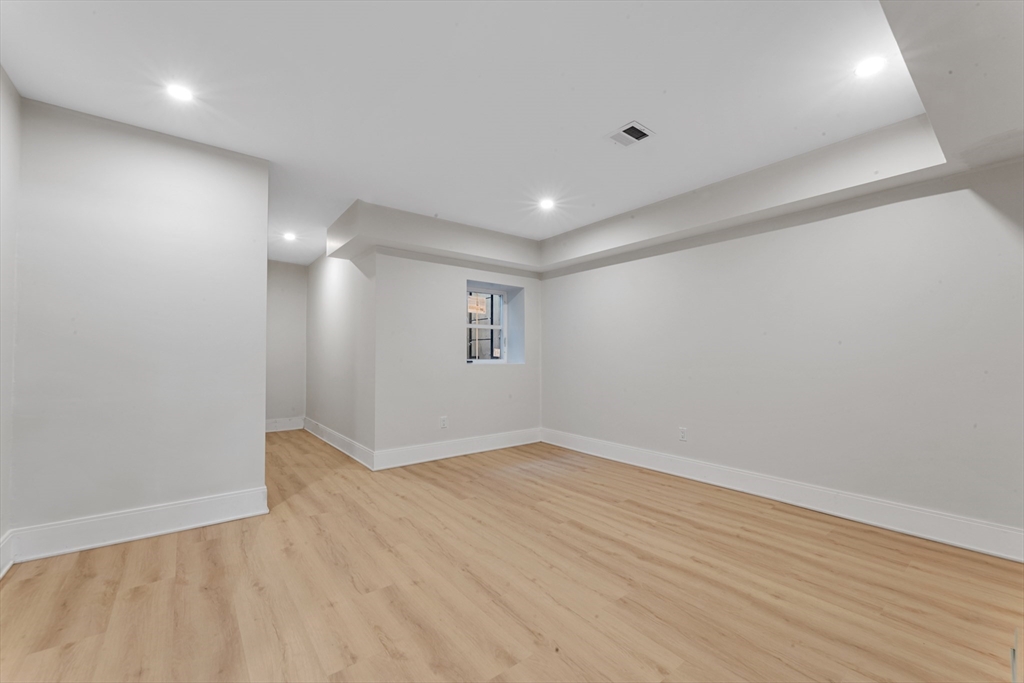 415 Poplar Street Boston, MA 02131 - Photo 27 of 31 an empty room with wooden floor and windows