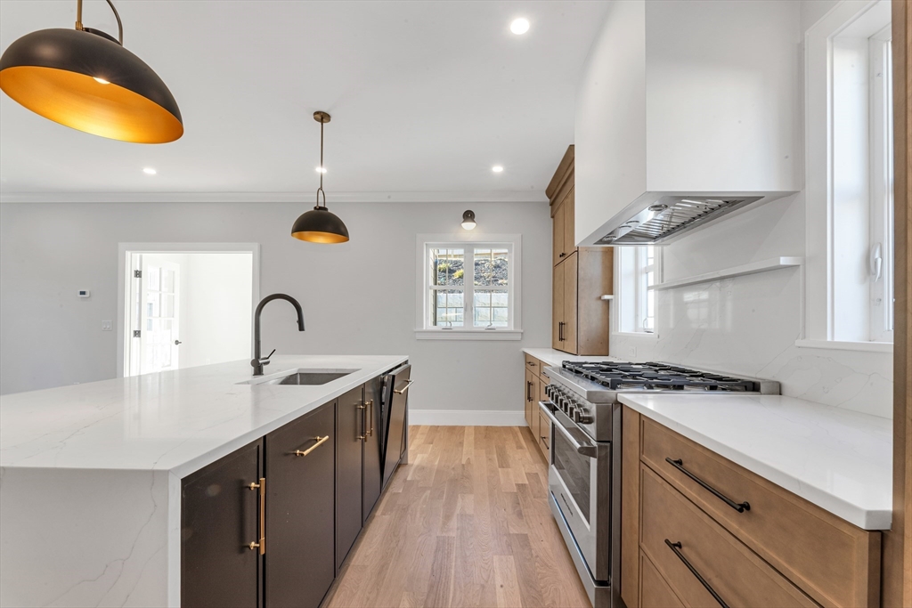 415 Poplar Street Boston, MA 02131 - Photo 7 of 31 a kitchen with stainless steel appliances granite countertop a sink a stove and a wooden floors