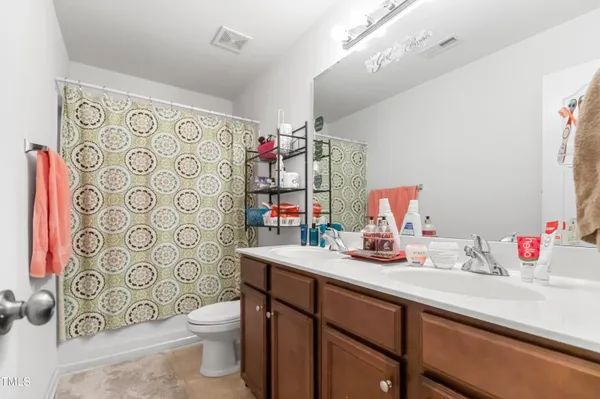 a bathroom with a sink vanity mirror and toilet
