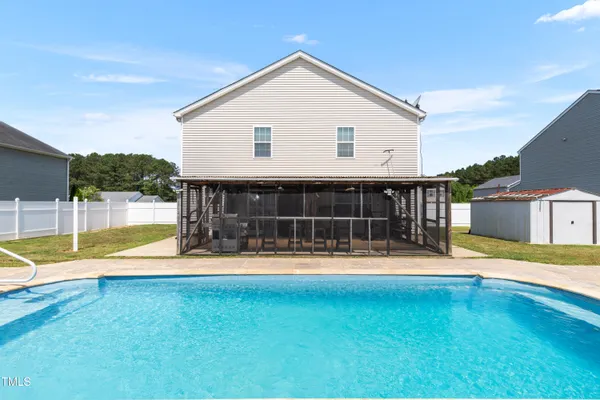 a view of a house with swimming pool and yard