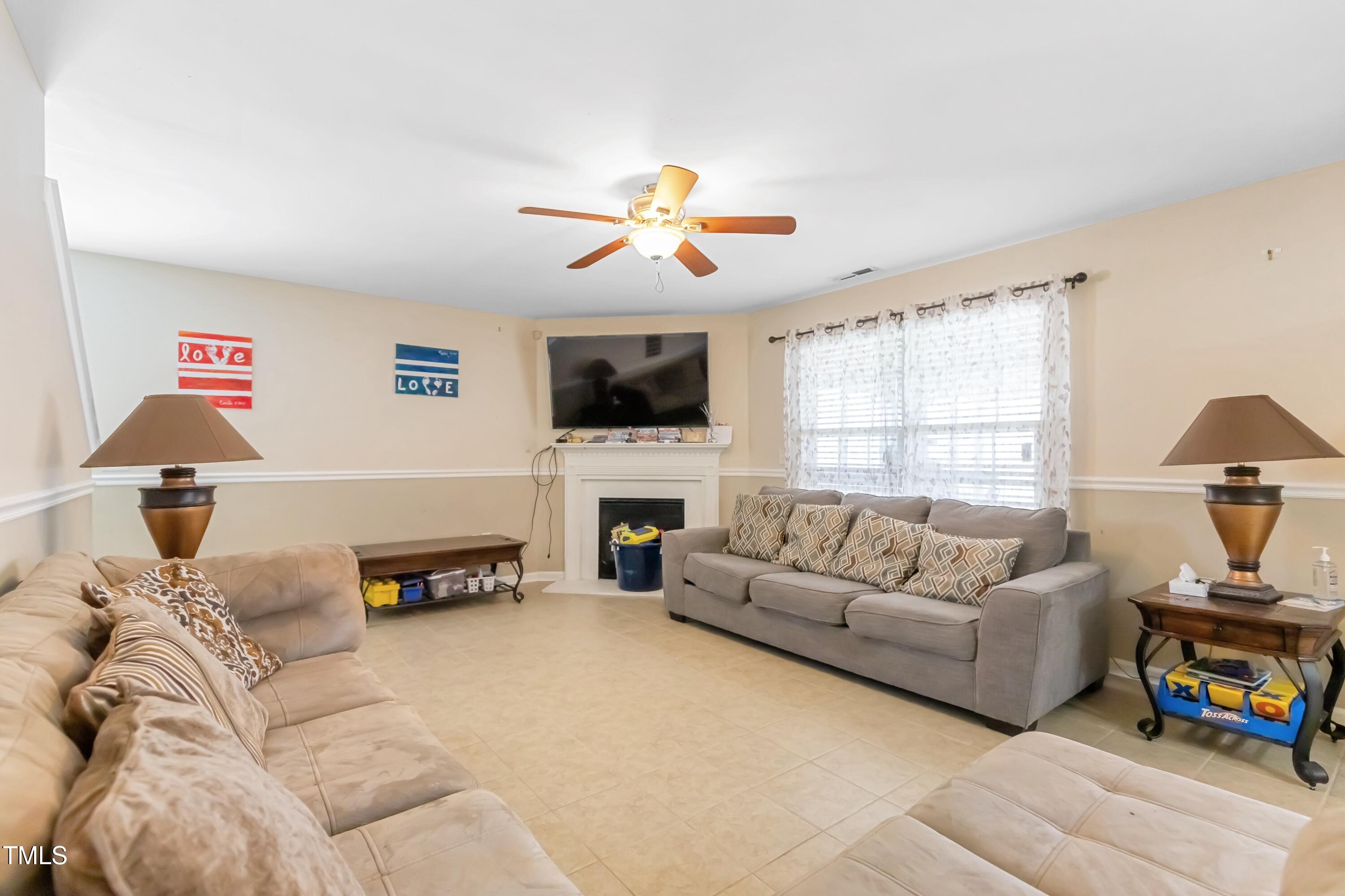 131 Botanical Court Bunnlevel, NC 28323 - Photo 3 of 18 a living room with furniture flat screen tv and a fireplace