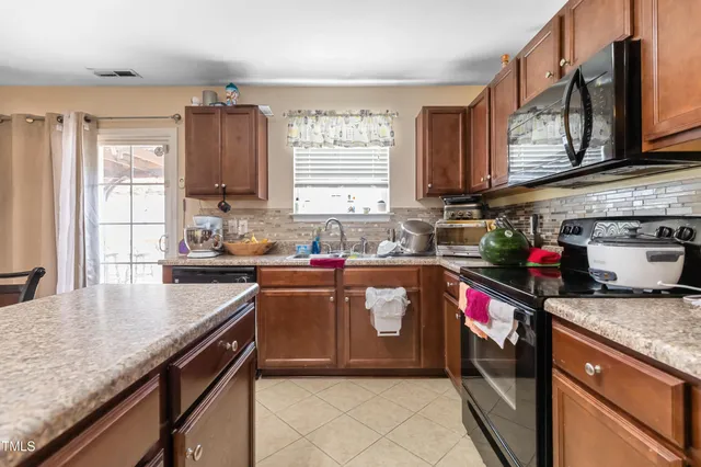 a kitchen with stainless steel appliances granite countertop a sink dishwasher stove and refrigerator