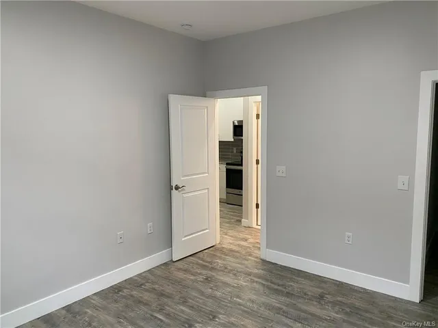 an empty room with wooden floor and closet