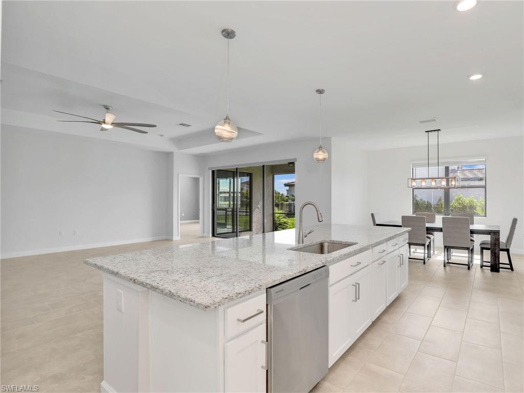 11391 Canopy Loop Fort Myers, FL 33913 - Photo 11 of 43 Kitchen with stainless steel dishwasher, a sink, a kitchen island with sink, white cabinetry, and a ceiling fan
