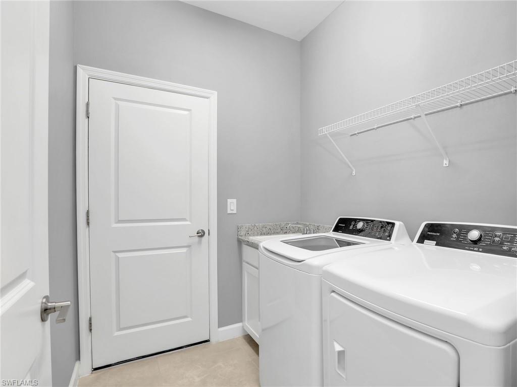 11391 Canopy Loop Fort Myers, FL 33913 - Photo 28 of 43 Laundry area featuring washing machine and dryer, cabinet space, baseboards, and light tile patterned floors