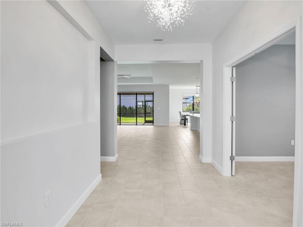 11391 Canopy Loop Fort Myers, FL 33913 - Photo 4 of 43 Hallway with a chandelier, light tile patterned floors, and baseboards