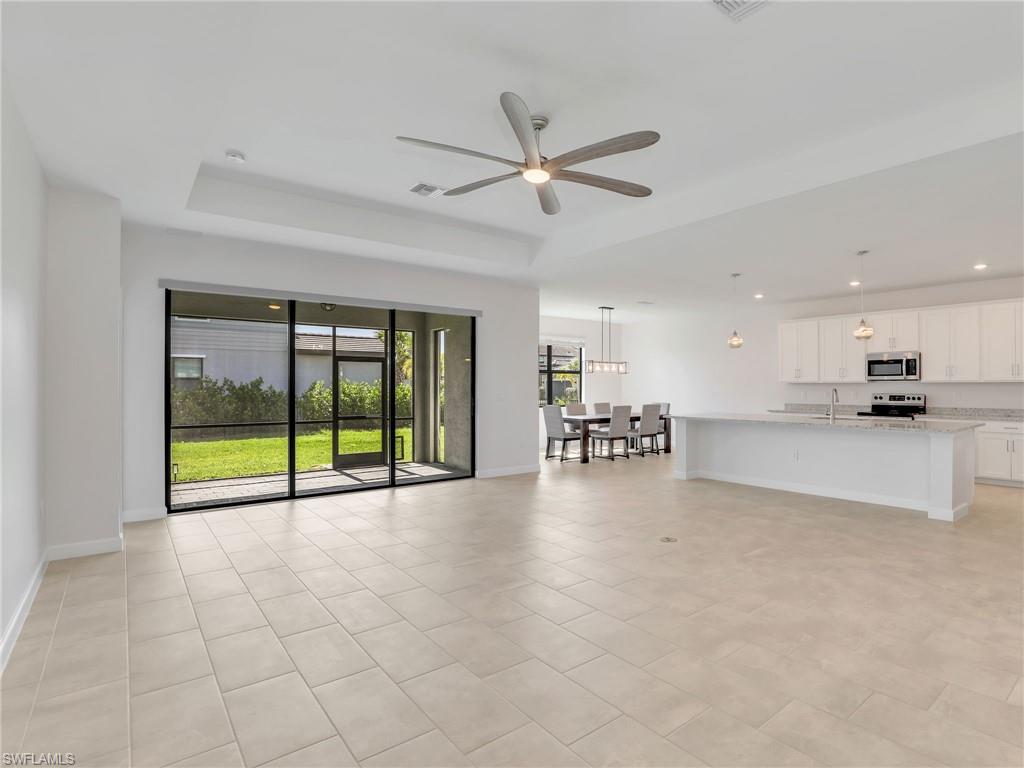 11391 Canopy Loop Fort Myers, FL 33913 - Photo 6 of 43 Unfurnished lGreat Room with a tray ceiling, ceiling fan, recessed lighting, baseboards, and light tile patterned floors